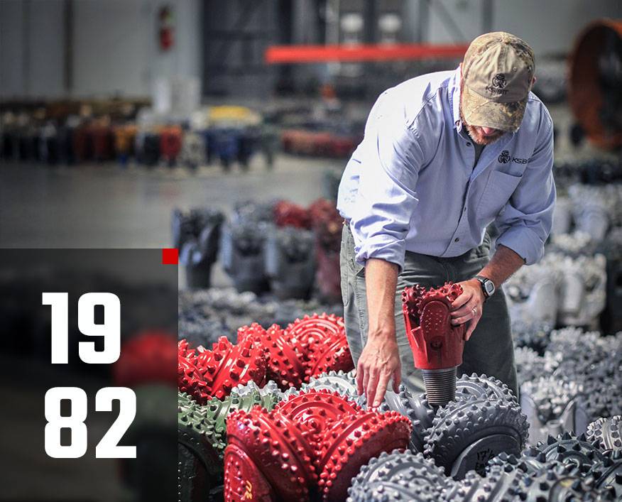 Worker inspecting HDD tools or tricone drill bits inside KS Bit warehouse.